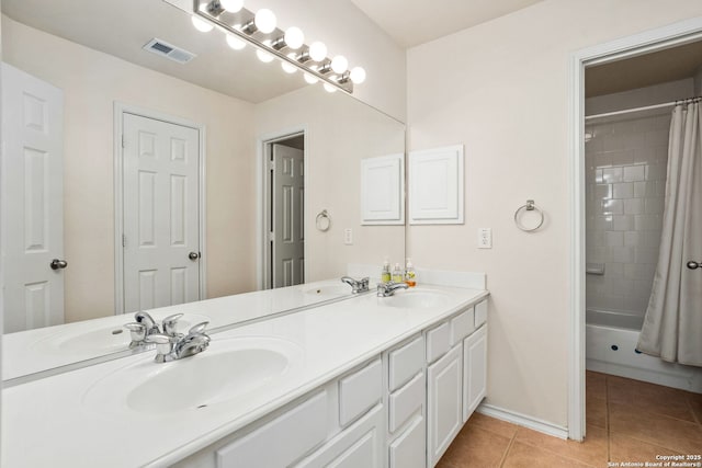 bathroom with double vanity, a sink, visible vents, and tile patterned floors