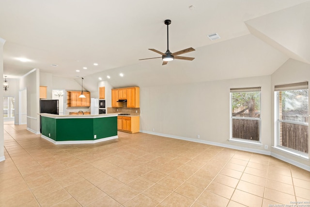 kitchen featuring lofted ceiling, visible vents, open floor plan, and freestanding refrigerator