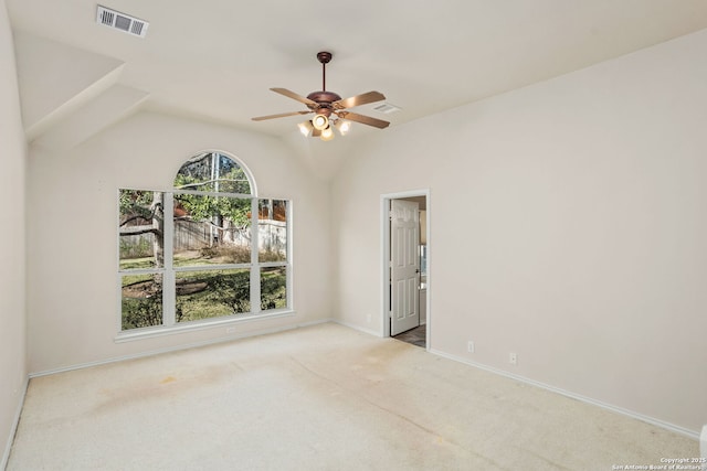 carpeted spare room featuring lofted ceiling, baseboards, visible vents, and ceiling fan