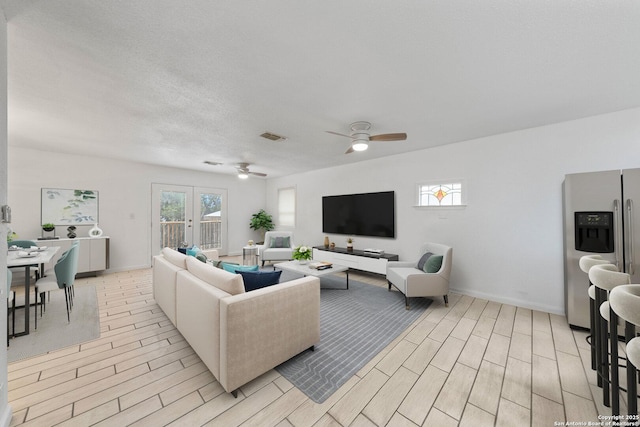 living room with french doors, wood finish floors, visible vents, and a healthy amount of sunlight