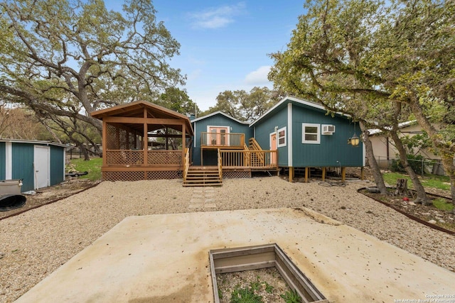 view of front of house with an outbuilding, a patio, and a wooden deck