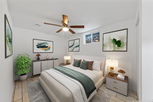 bedroom featuring a ceiling fan, visible vents, and light wood finished floors