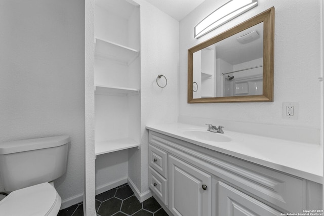 bathroom with toilet, tile patterned floors, baseboards, and vanity