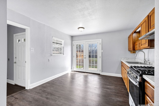 kitchen featuring brown cabinetry, range with gas cooktop, light countertops, french doors, and a sink