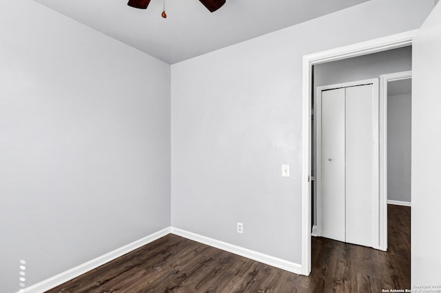 unfurnished bedroom with a ceiling fan, dark wood-style flooring, and baseboards