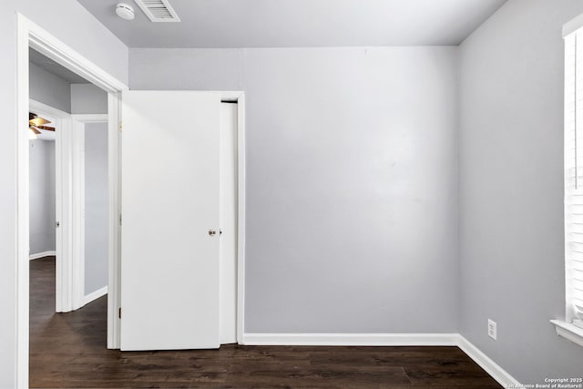 spare room with visible vents, dark wood finished floors, and baseboards