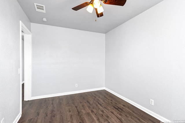 spare room featuring dark wood-style floors, baseboards, visible vents, and ceiling fan