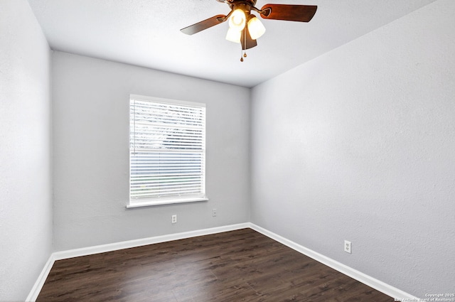 unfurnished room featuring ceiling fan, dark wood-style flooring, plenty of natural light, and baseboards