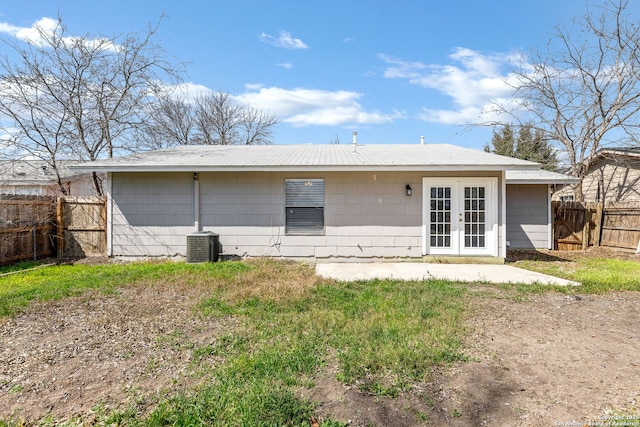 rear view of house featuring french doors, cooling unit, and fence