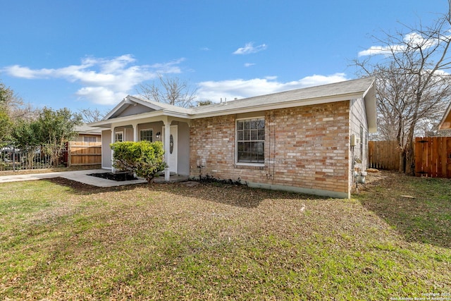 single story home with brick siding, a front yard, and fence