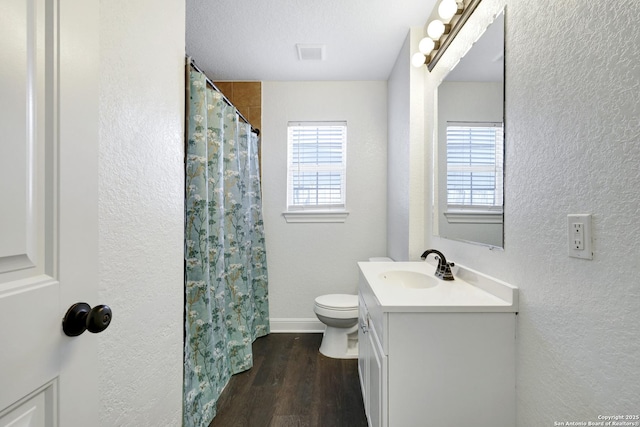 full bathroom with visible vents, a textured wall, toilet, wood finished floors, and vanity