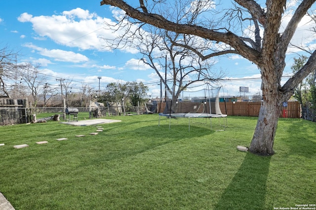 view of yard featuring a trampoline and a fenced backyard