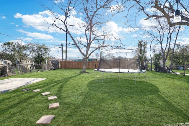 view of yard featuring a trampoline and a fenced backyard