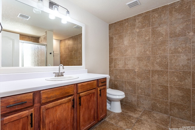 full bathroom with visible vents, toilet, a shower stall, and vanity