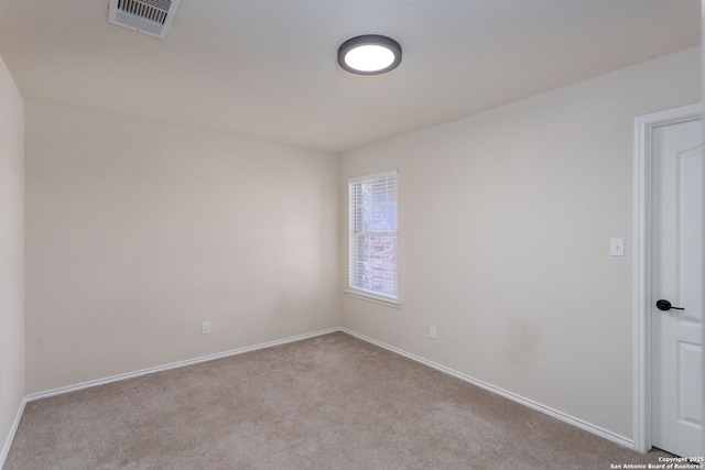 spare room featuring carpet, visible vents, and baseboards