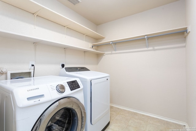 washroom featuring baseboards, laundry area, visible vents, and washer and dryer