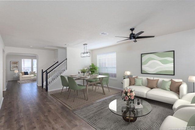 living area with baseboards, visible vents, ceiling fan, wood finished floors, and stairs