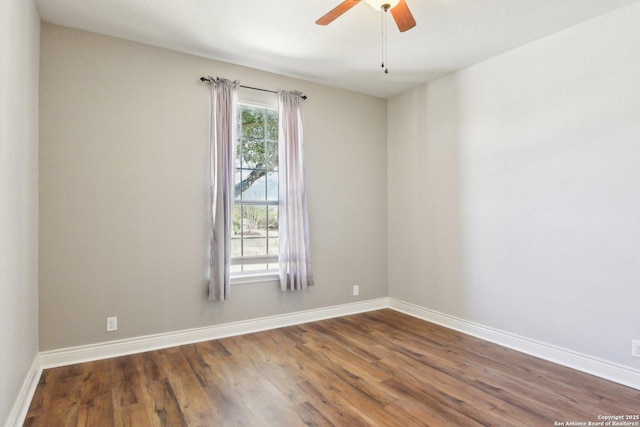 empty room featuring a ceiling fan, baseboards, and wood finished floors