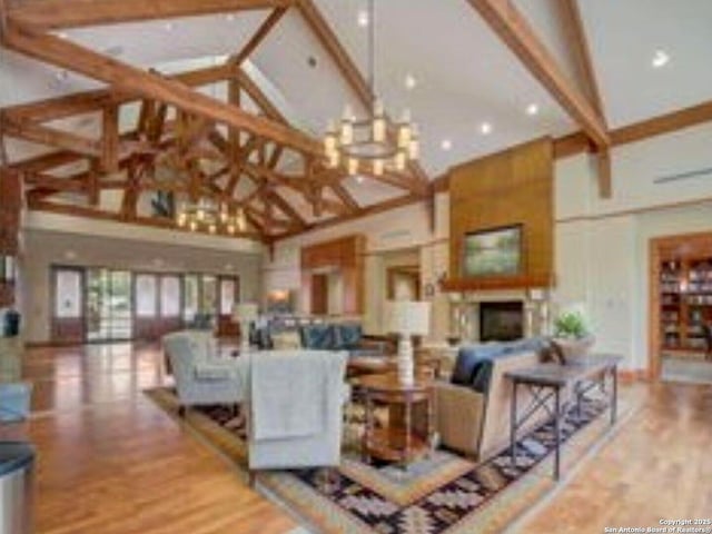 living room featuring a fireplace, high vaulted ceiling, beamed ceiling, and wood finished floors