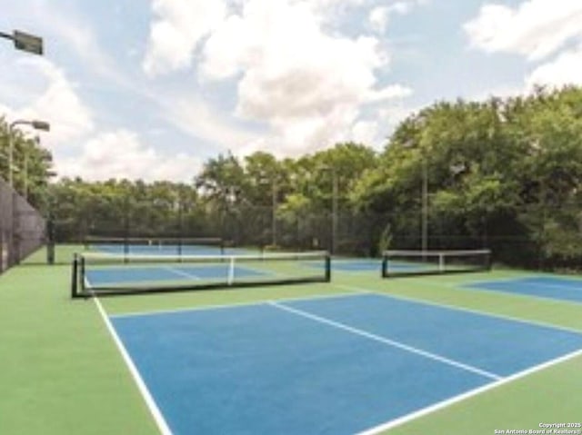 view of tennis court featuring fence