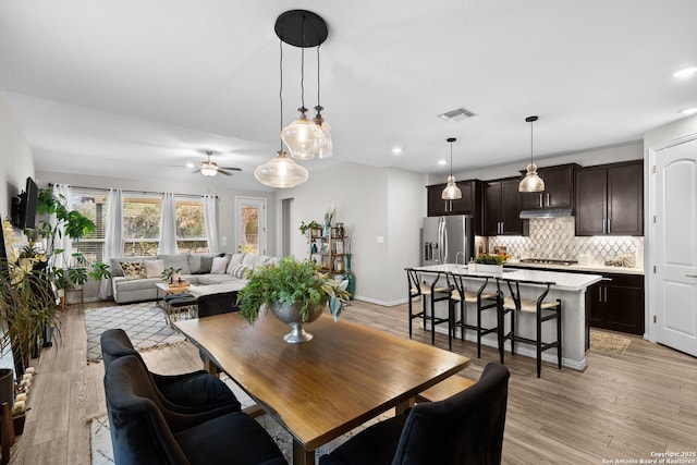 dining area with light wood-type flooring, visible vents, and recessed lighting