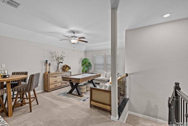 rec room featuring light carpet, baseboards, visible vents, ceiling fan, and a textured ceiling