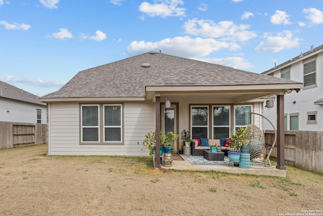 rear view of house with a shingled roof, fence, and a patio