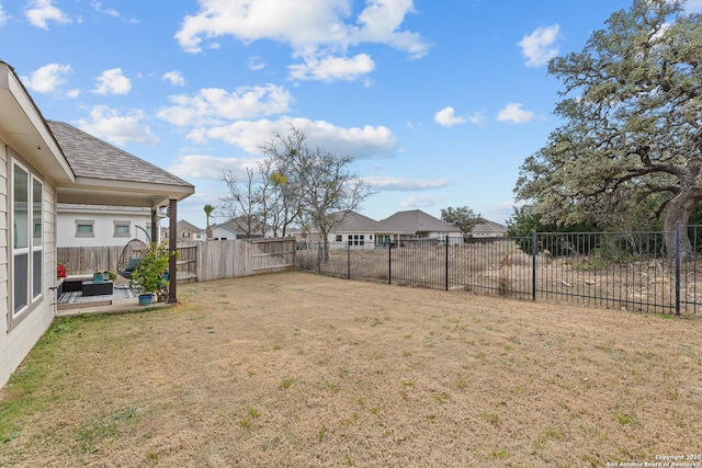 view of yard featuring a residential view, a fenced backyard, and a patio