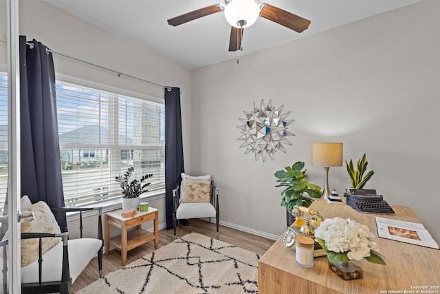 sitting room with ceiling fan, baseboards, and wood finished floors