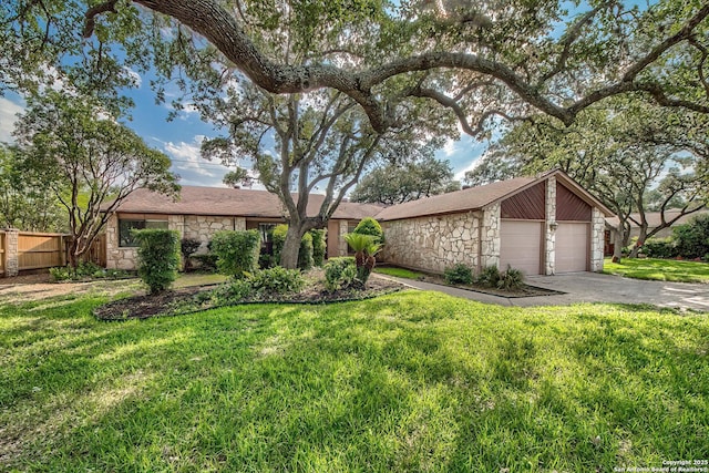 mid-century modern home featuring a garage, stone siding, fence, and a front lawn