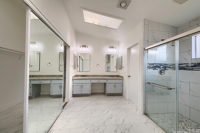 bathroom with marble finish floor, vaulted ceiling, a shower stall, and vanity