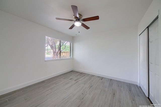 unfurnished bedroom with a closet, light wood-type flooring, a ceiling fan, and baseboards