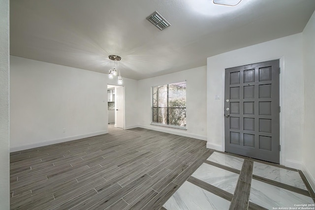 entryway featuring baseboards, visible vents, and wood finished floors