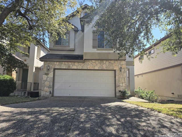 view of front of house featuring an attached garage, stone siding, concrete driveway, and stucco siding