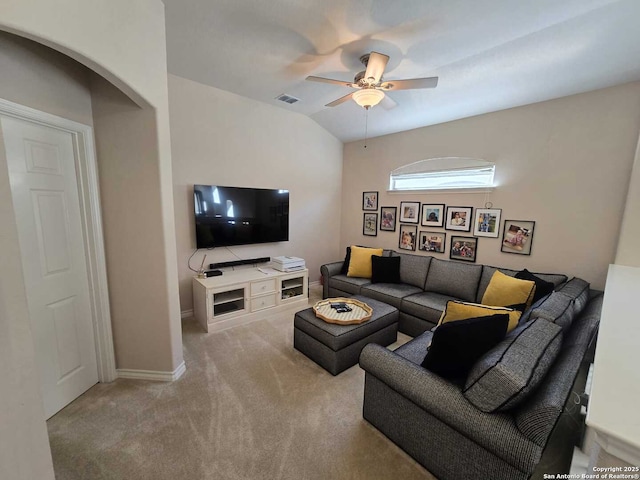 living area featuring arched walkways, visible vents, a ceiling fan, vaulted ceiling, and carpet floors