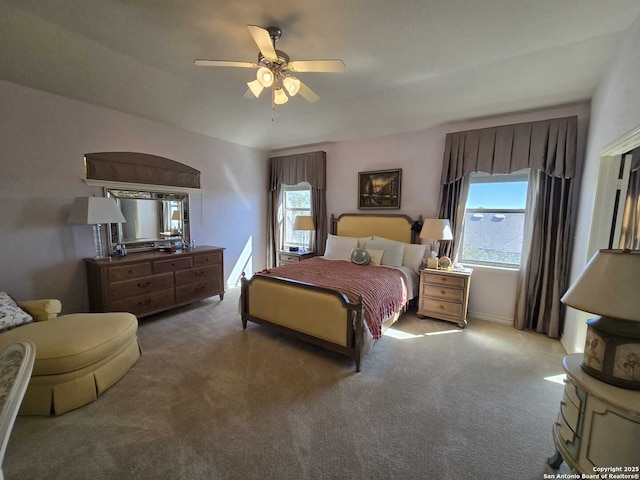 carpeted bedroom featuring multiple windows, ceiling fan, and baseboards