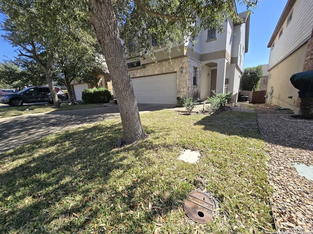 view of front of property with a garage, a front yard, stone siding, and driveway