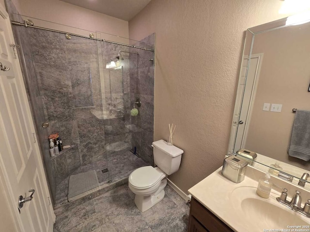 full bath featuring a textured wall, a tile shower, vanity, and toilet