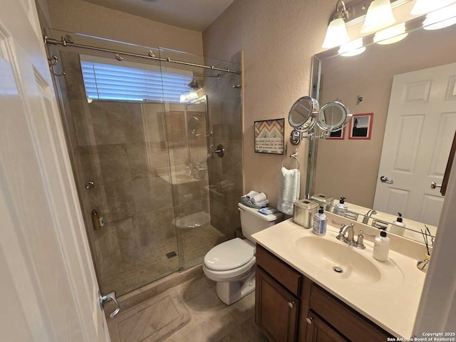 bathroom with vanity, tile patterned flooring, a shower stall, and toilet