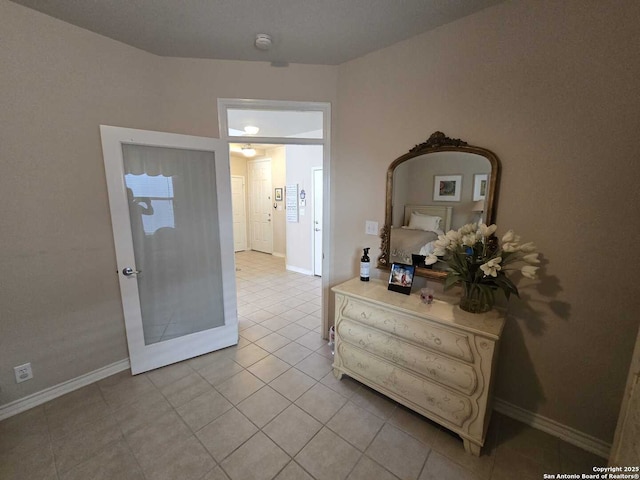 hallway featuring light tile patterned floors and baseboards