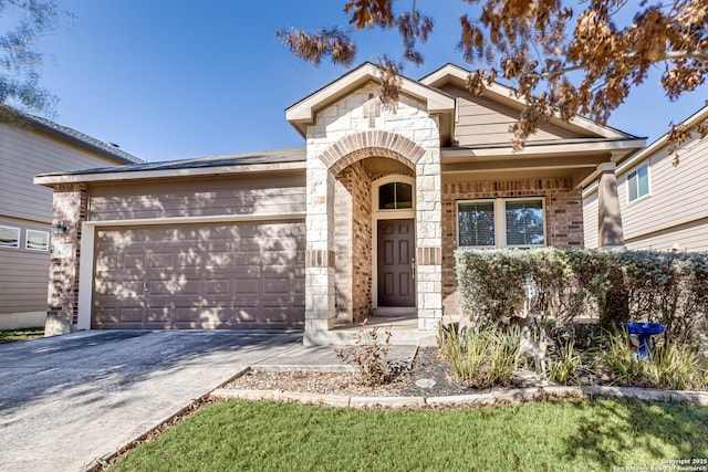 view of front of house featuring a garage, stone siding, brick siding, and driveway