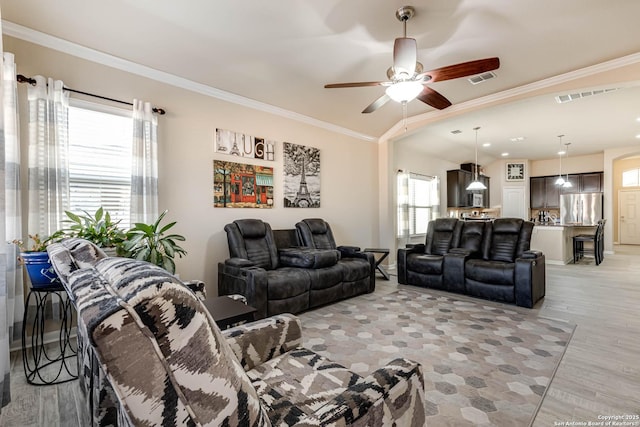 living room with ceiling fan, visible vents, and crown molding