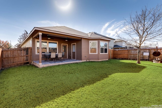 back of house with a yard, a fenced backyard, ceiling fan, and a patio