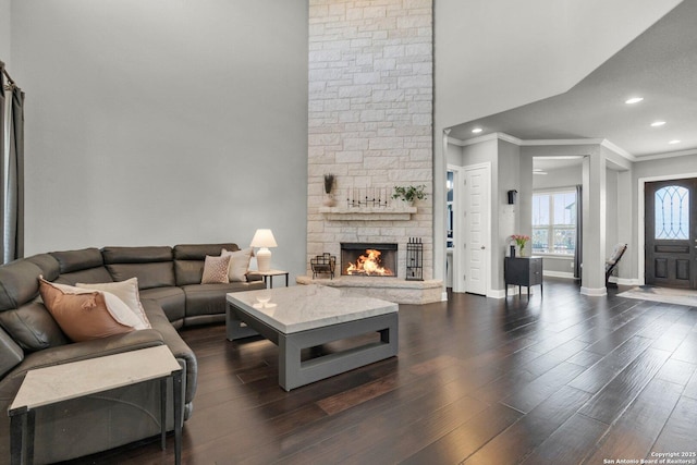 living room with baseboards, dark wood-style floors, ornamental molding, a fireplace, and recessed lighting