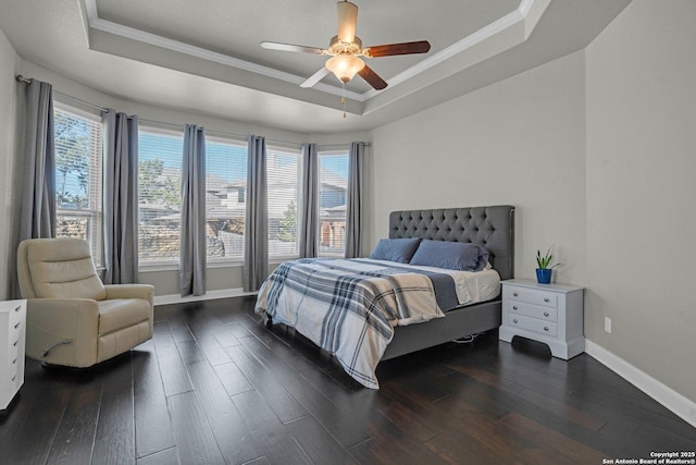 bedroom featuring a tray ceiling, dark wood finished floors, and crown molding