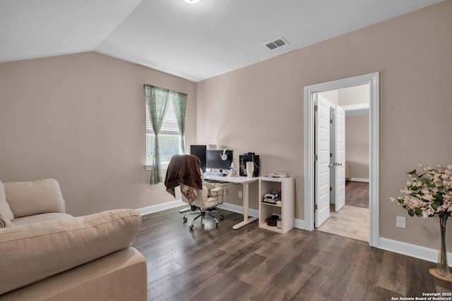 office area featuring lofted ceiling, wood finished floors, visible vents, and baseboards