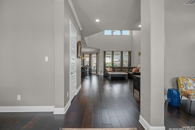 corridor featuring dark wood-type flooring, recessed lighting, visible vents, and baseboards