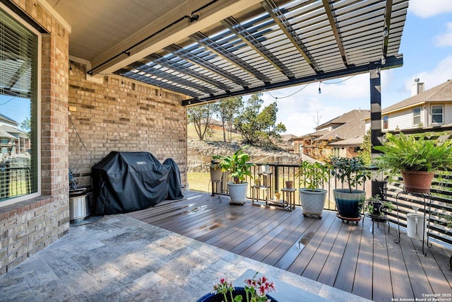 wooden terrace featuring area for grilling and a pergola