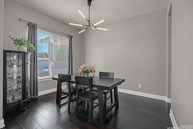 dining room featuring baseboards, a chandelier, and dark wood-type flooring