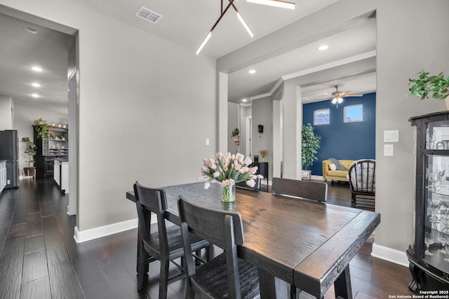 dining room featuring dark wood-style floors, baseboards, visible vents, and a ceiling fan